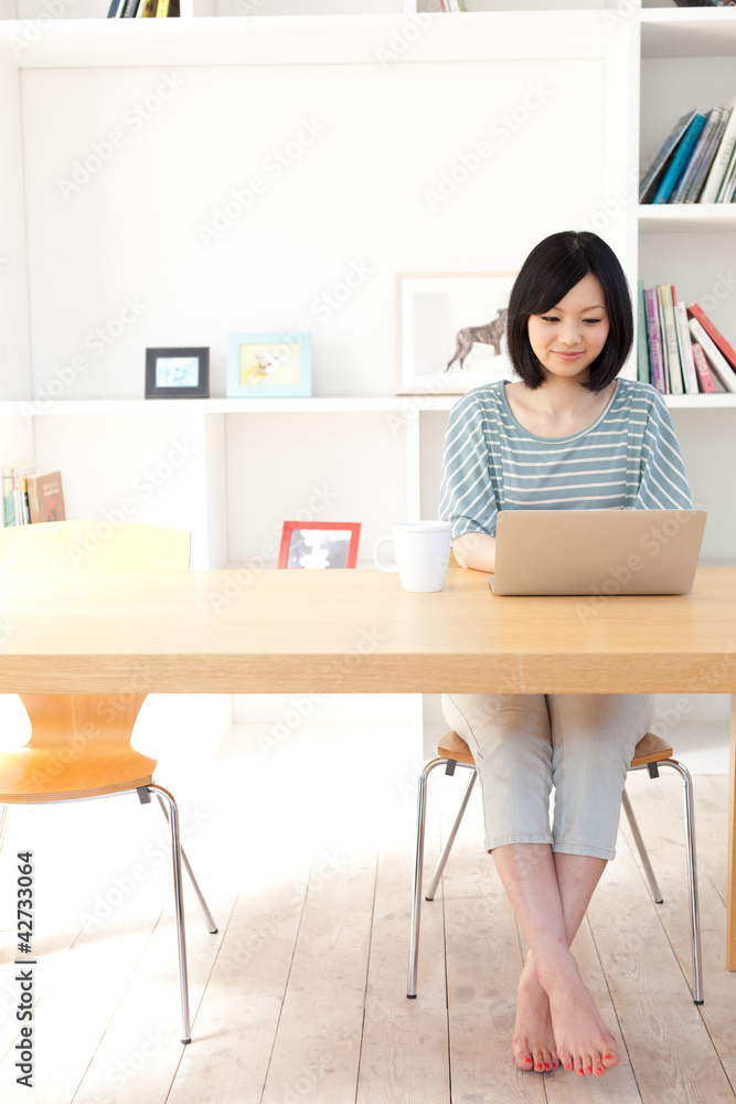 一位使用笔记本电脑的年轻亚洲女性