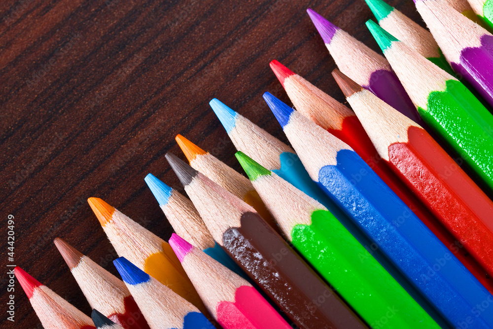 Multicolored pencils over brown background