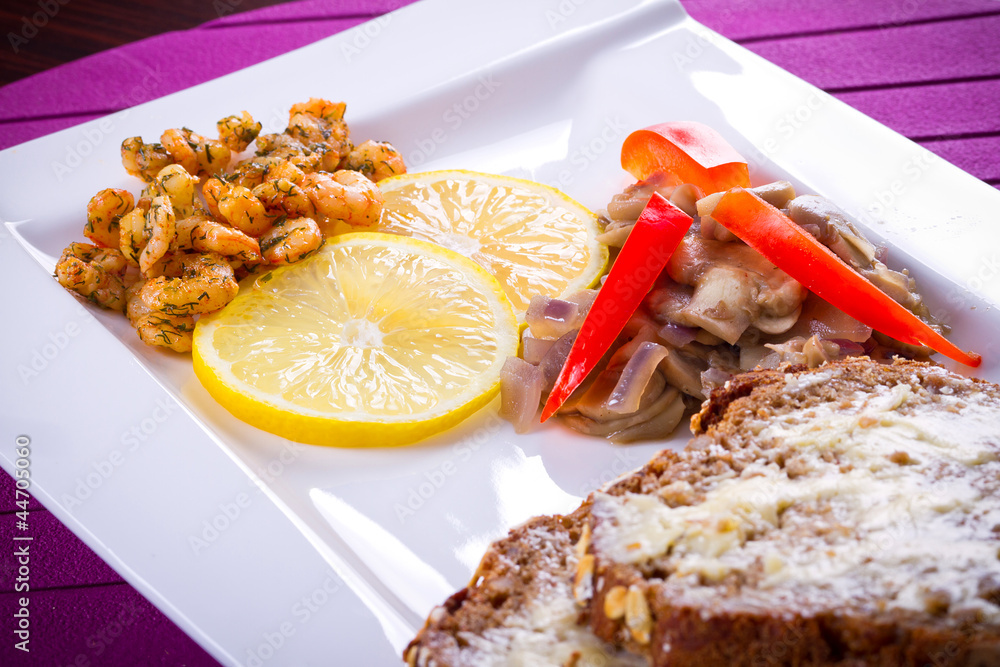 Starter with fried prawns with lemon, mashrooms and brown bread