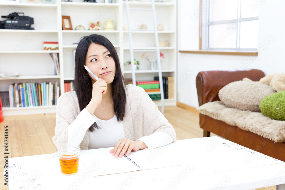 一个年轻的亚洲女人在房间里学习