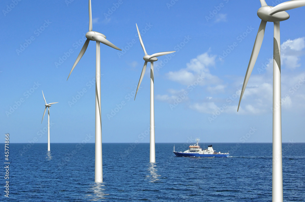 Windräder auf See mit kreuzendem Schiff