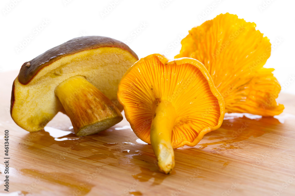 Golden chanterelle and boletus badius fungi on the cutting board