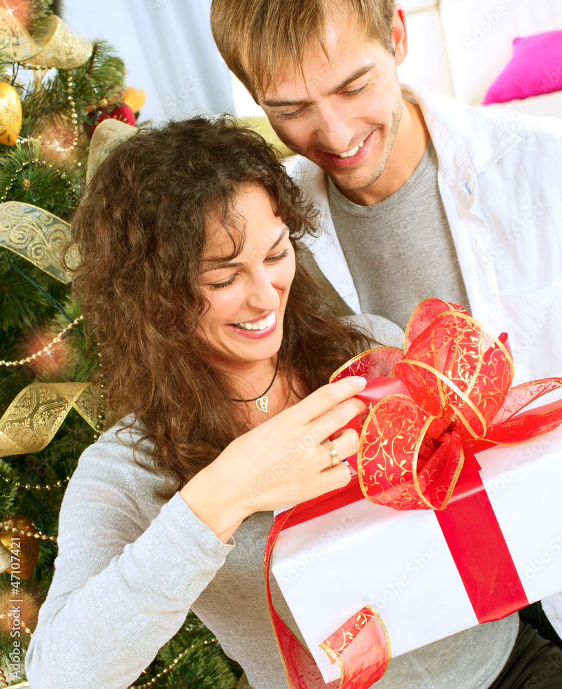 Happy Couple Opening Christmas Gift. Christmas Family