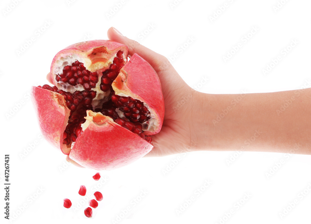 Sliced pomegranate in hand and seeds isolated