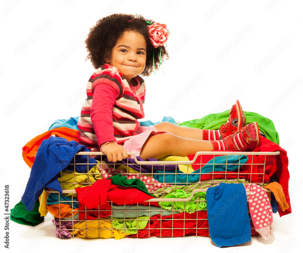 Black girl sitting in the basket with clothes