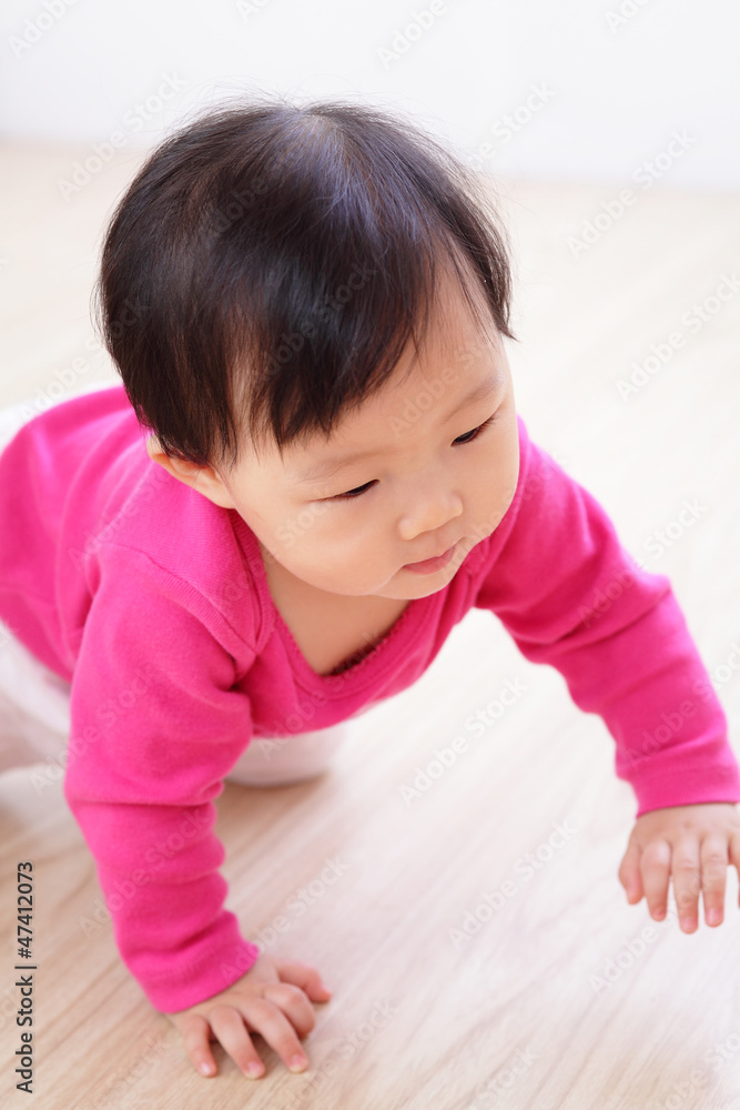 在客厅地板上爬行的女婴