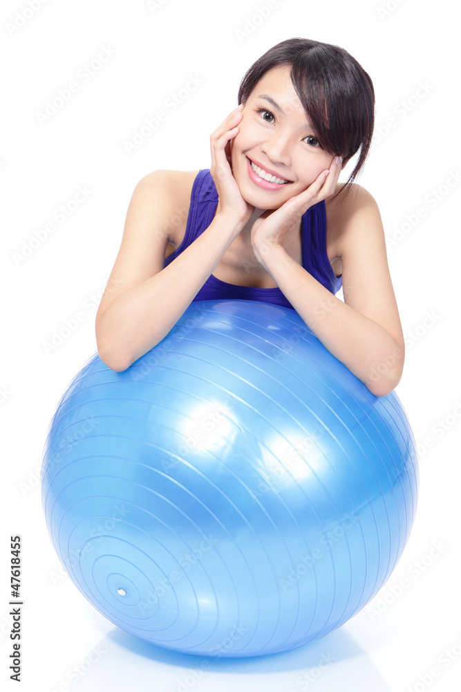 Woman smiling leaning on pilates ball