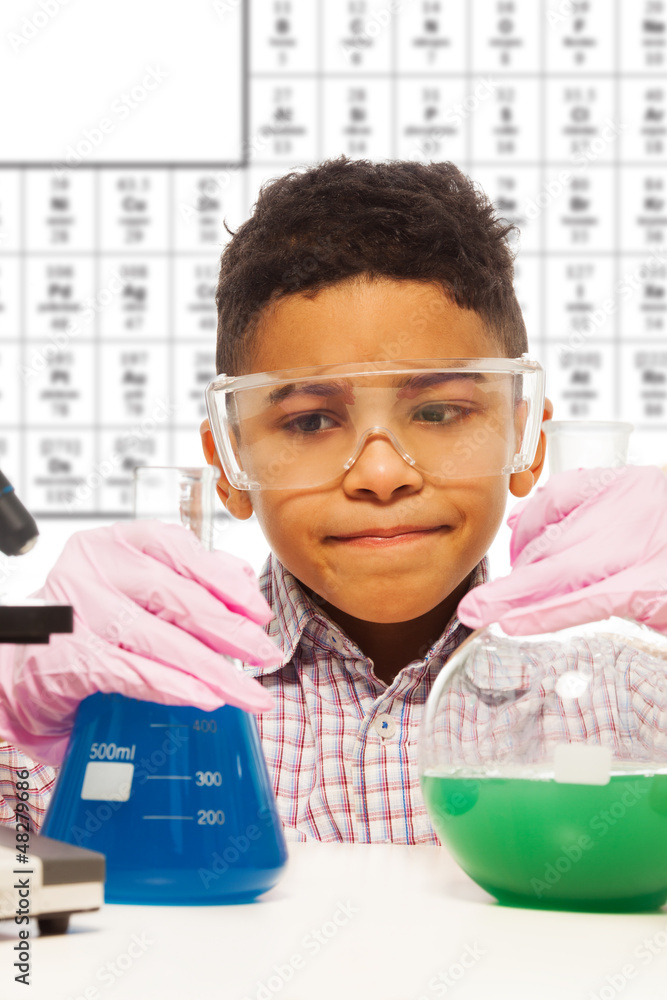 Black little boy experiments with chemistry