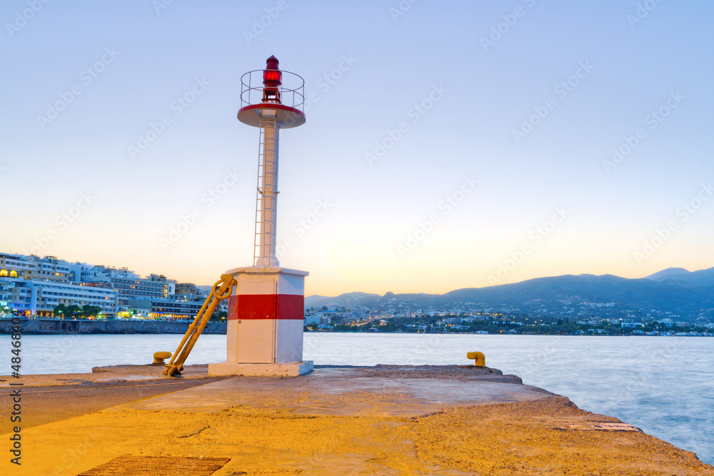 Lighthouse of Agios Nikolaos city at sunset on Crete, Greece