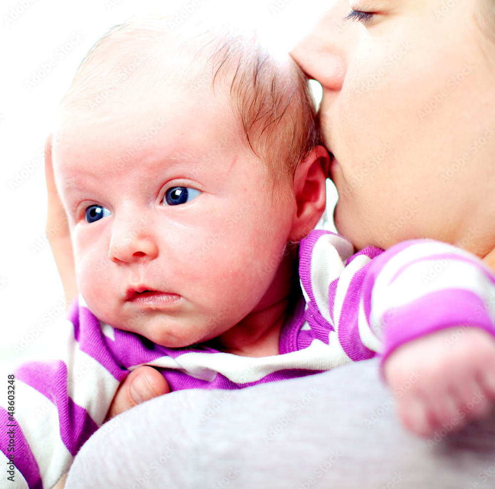 Mother kissing her newborn baby