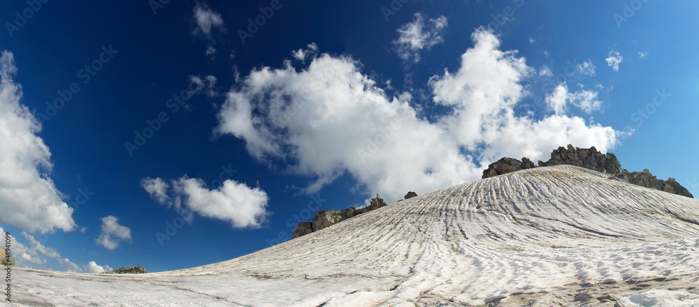 High snowy mountains and bright sky. Natural winter landscape