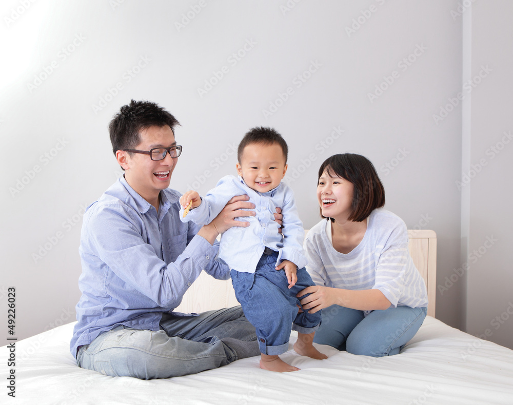 happy family playing on white bed