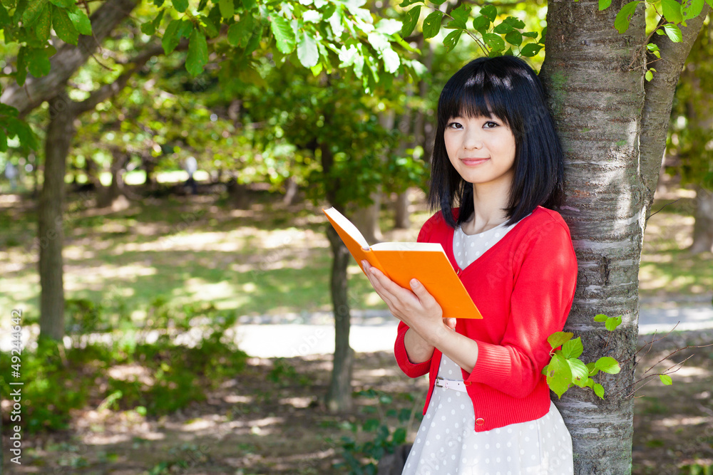 一个活跃的亚洲女人在公园里看书