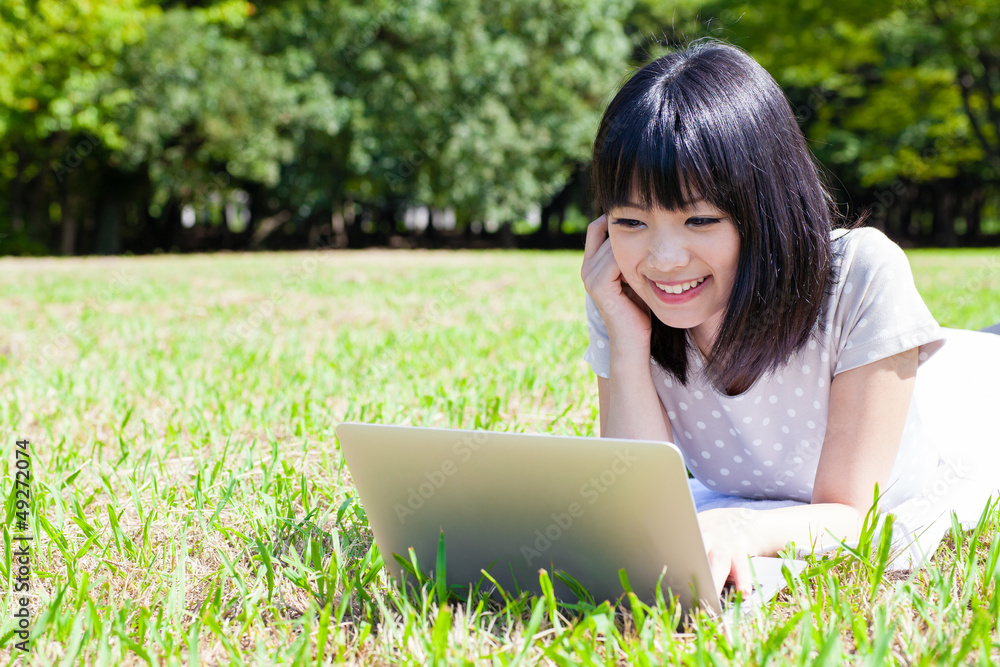 attractive asian woman using smart phone in the park