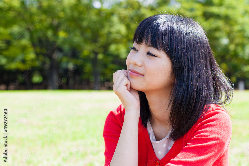 迷人的亚洲女人在公园放松