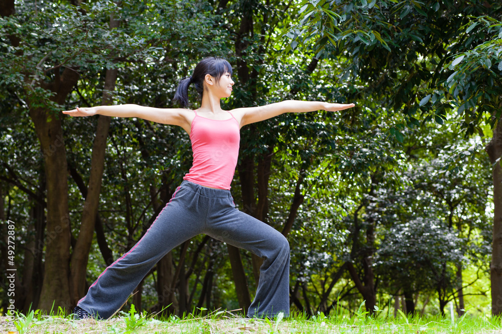 attractive asian woman stretching the park