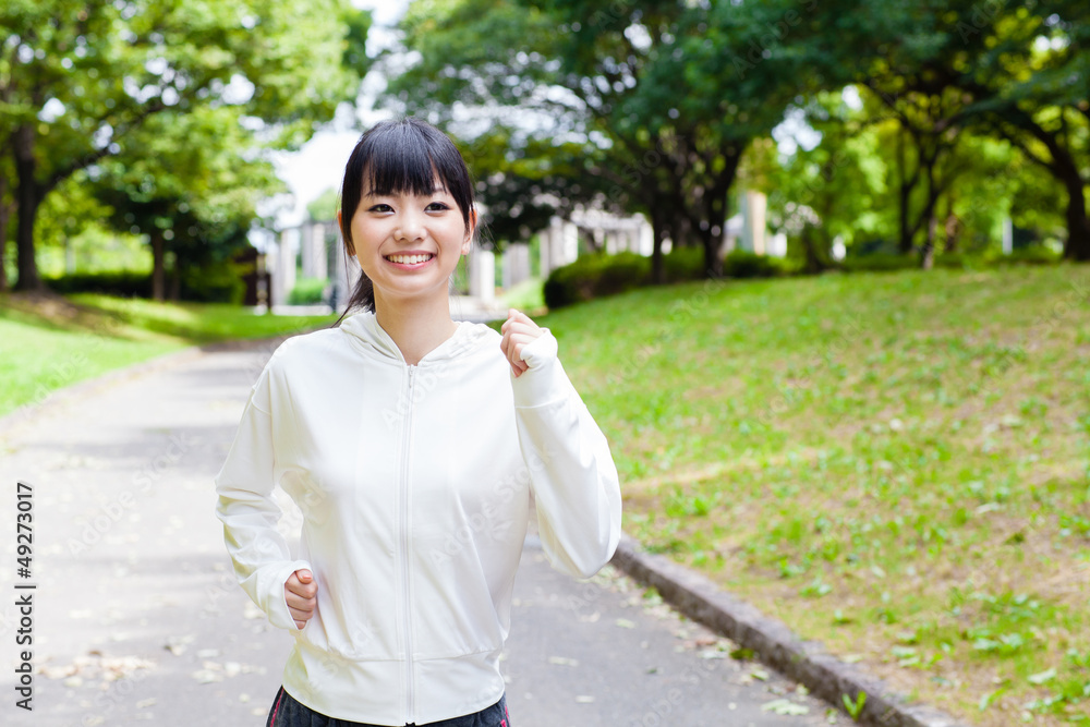 attractive asian woman jogging  in the park