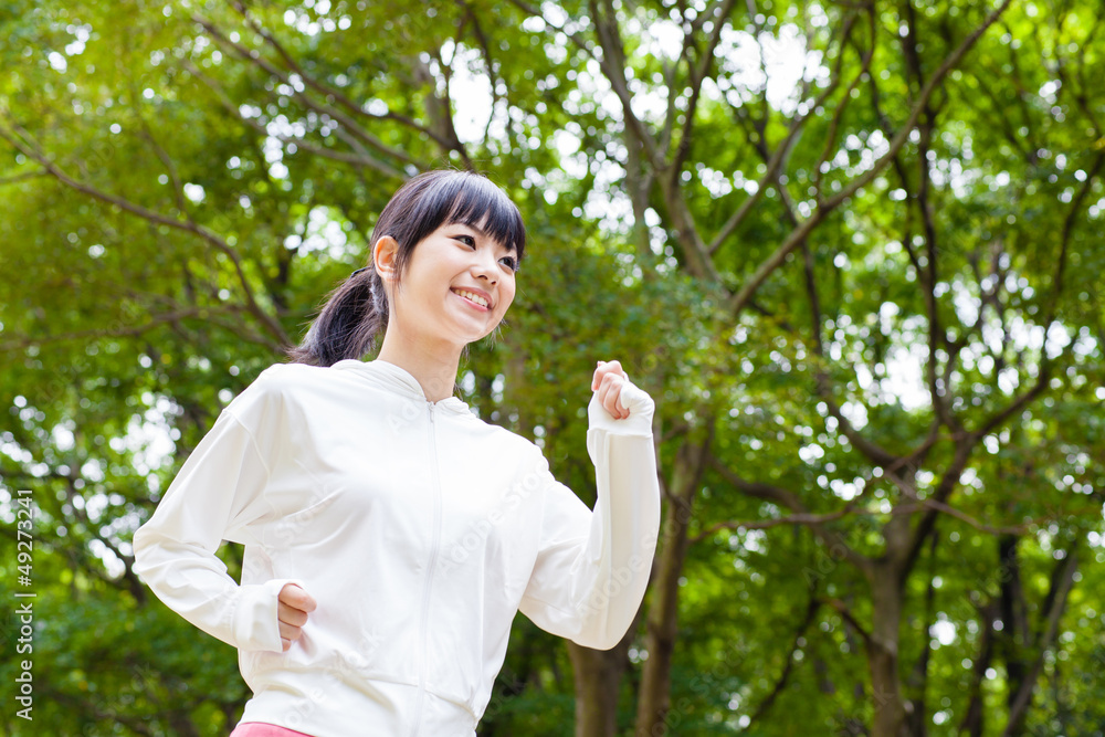 attractive asian woman running in the park