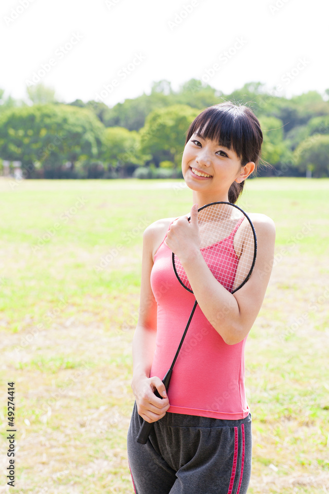 attractive asian woman with racket in the park