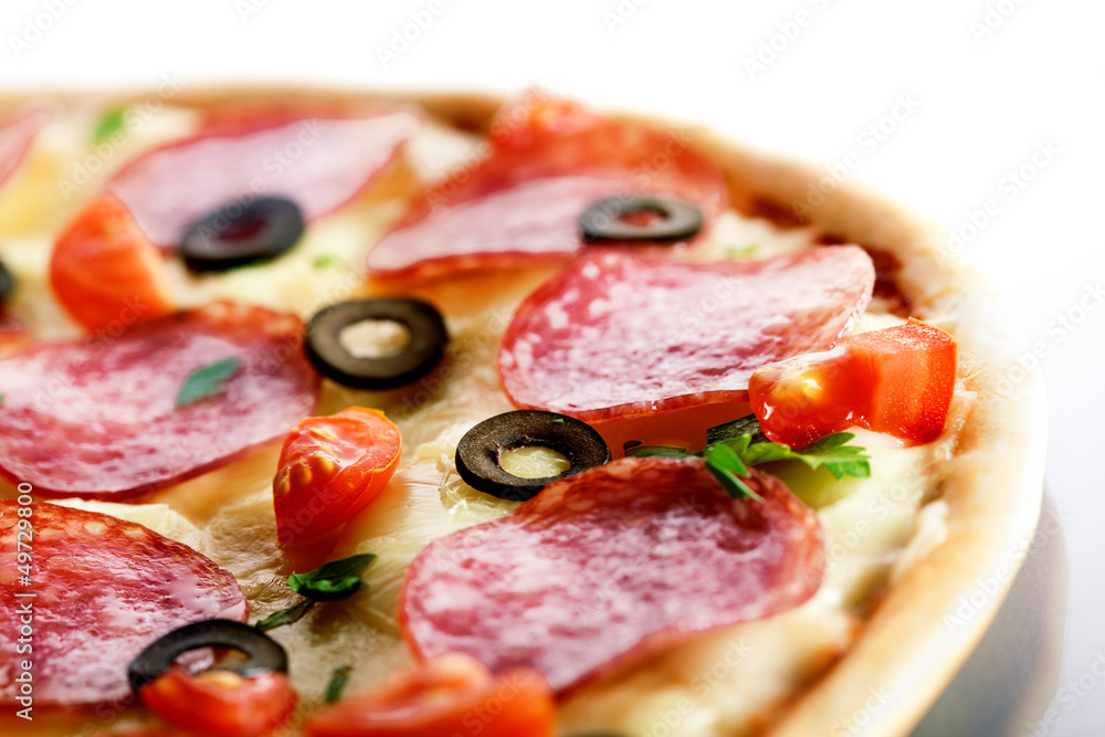 Pizza with salami and black olives. macro