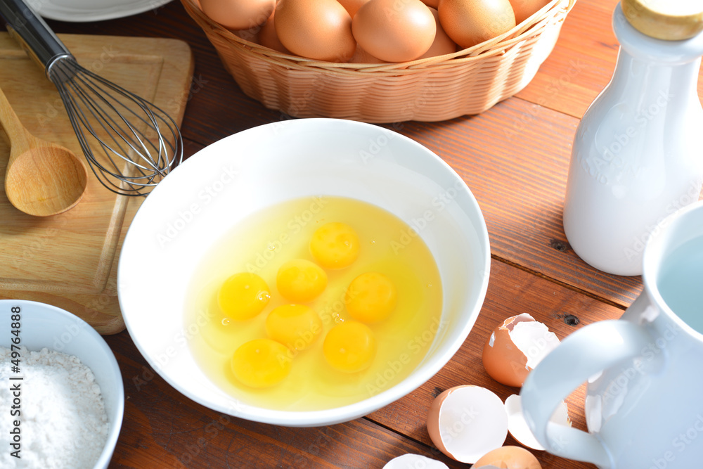 eggs and a whisk on wooden table