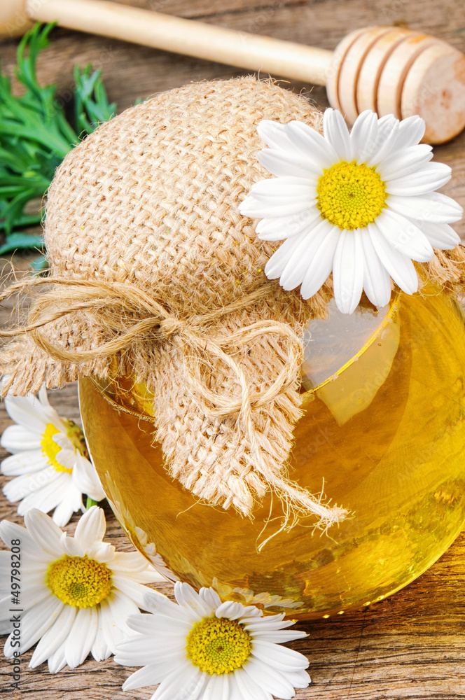 Pot of honey with daisies