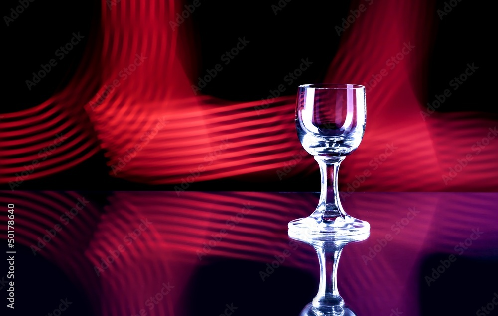 Glass of alcohol on disco background, party