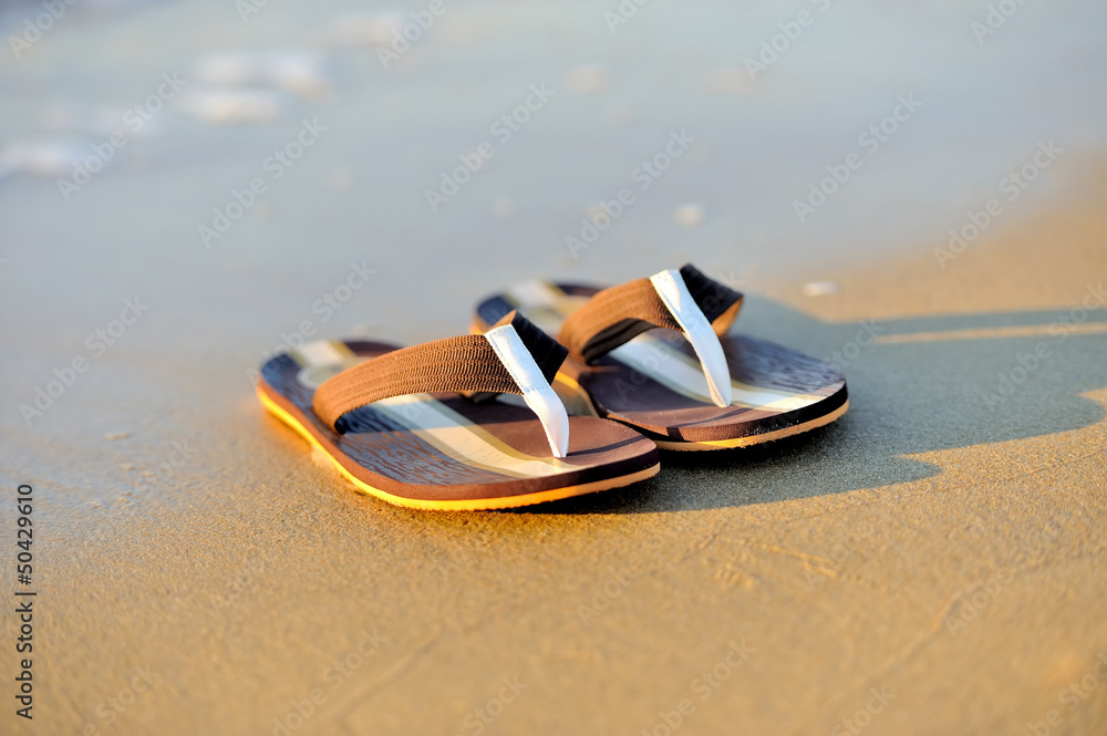 Flip flops on a sandy ocean beach