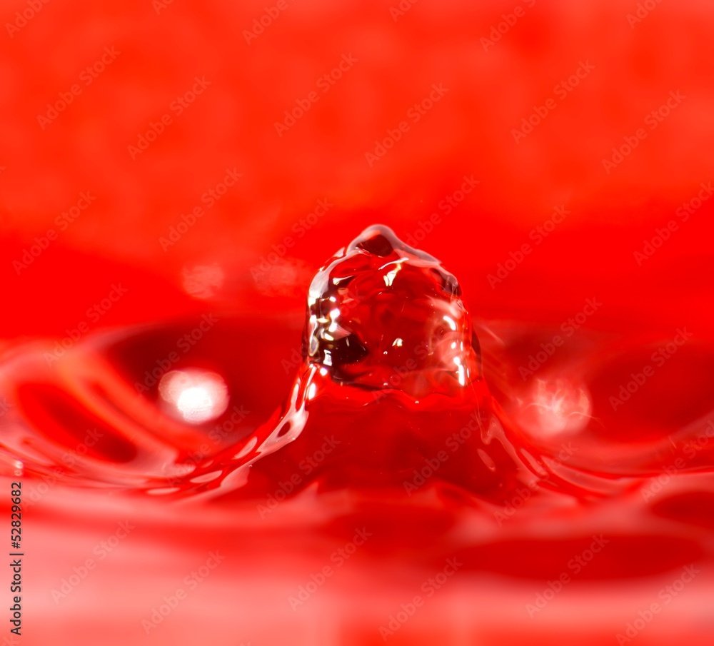 Water splash macro closeup, red background