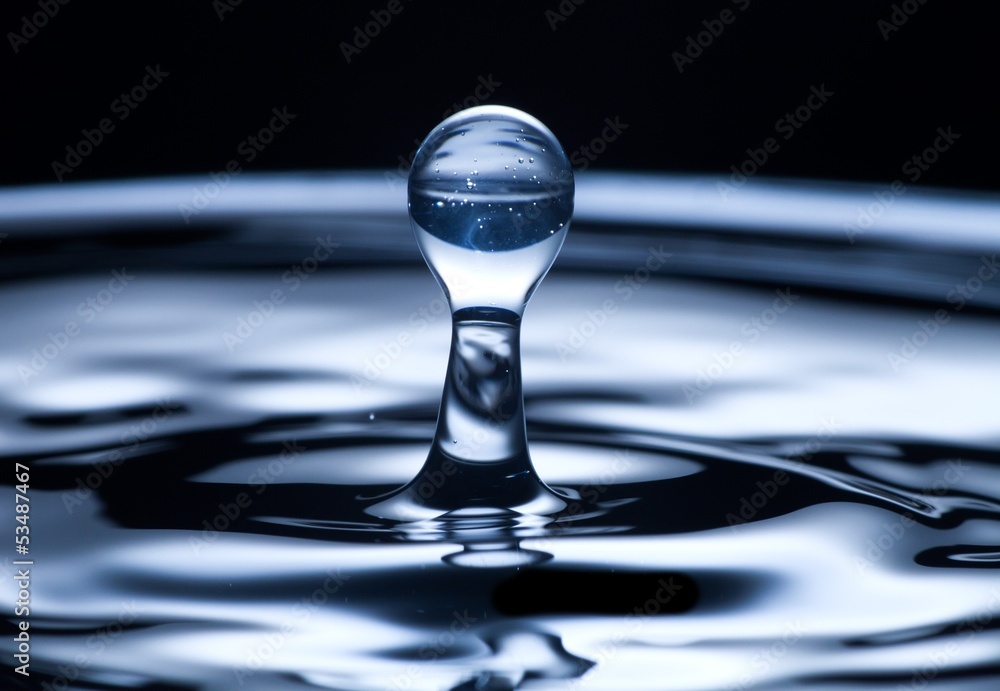 Water drop and splash close up, dark blue color