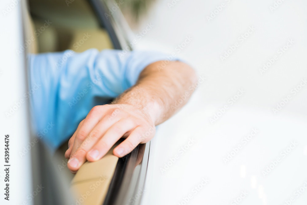 man hand is on the door of the car