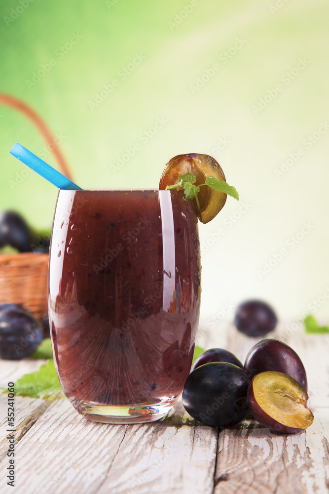 Fresh plum drink on wood