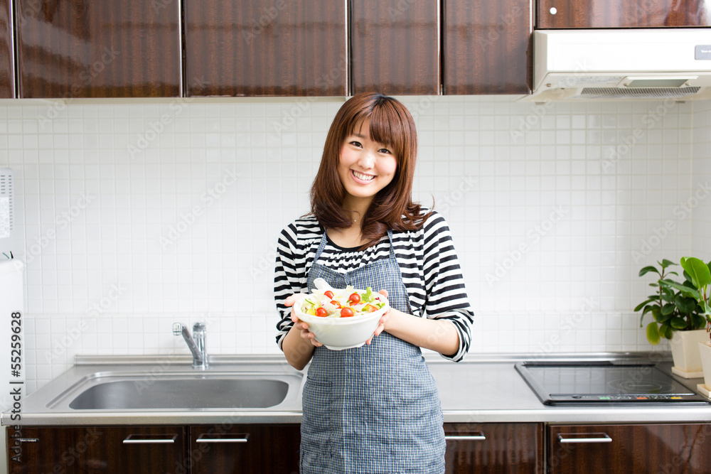 美丽的亚洲女人在厨房做饭