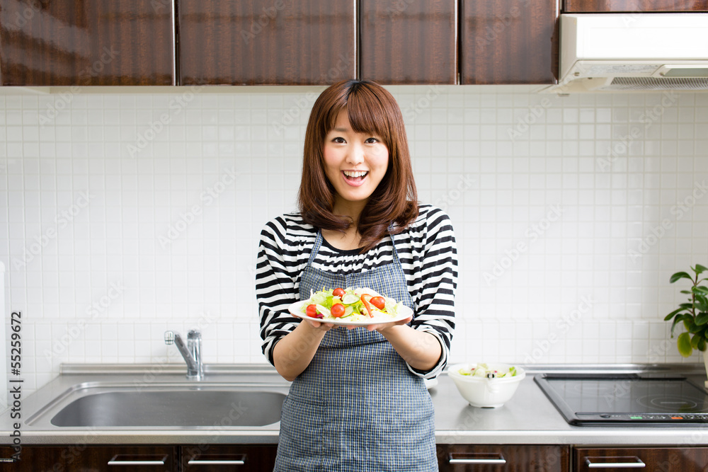 美丽的亚洲女人在厨房做饭