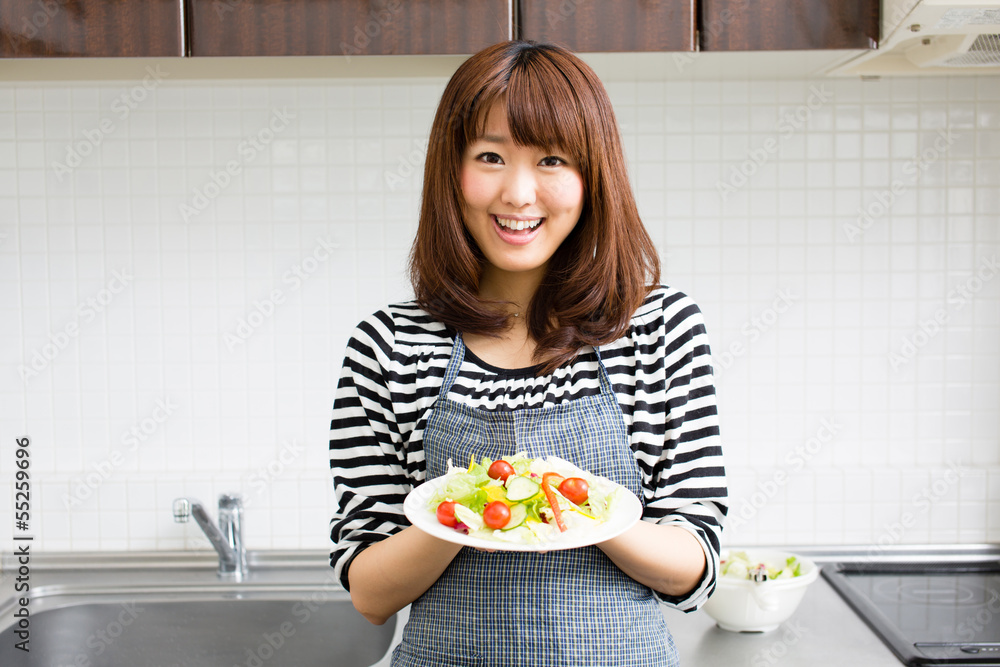 美丽的亚洲女人在厨房做饭