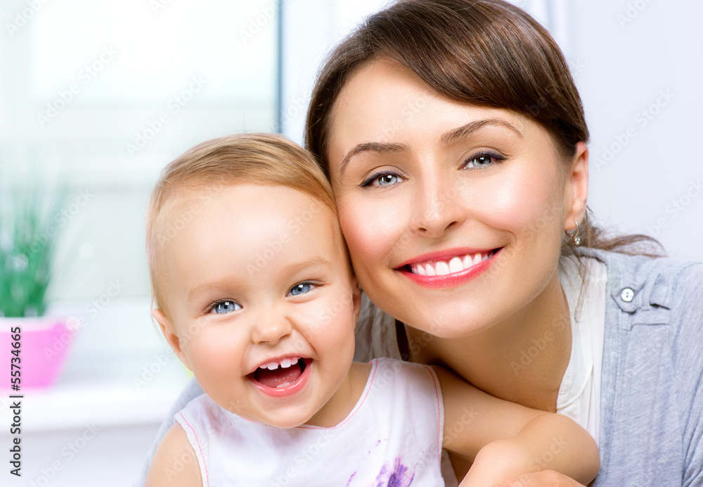 Happy Smiling Mother and Baby kissing and hugging at Home.