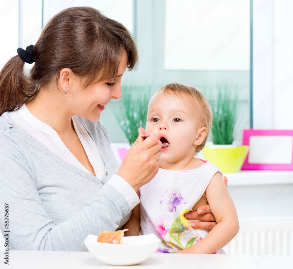 Mother Feeding Her Baby Girl with a Spoon