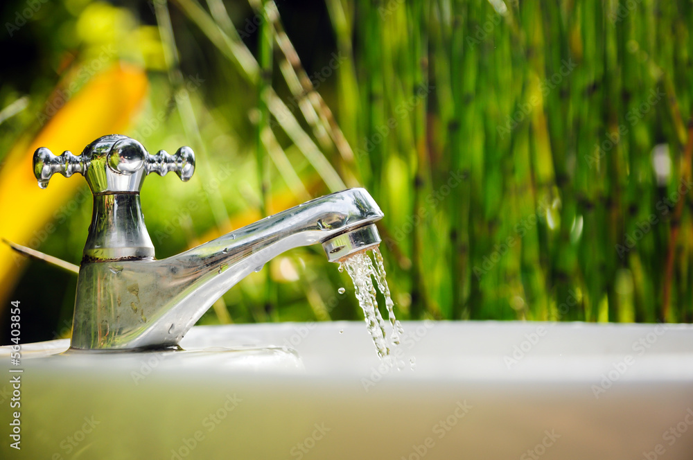 水龙头滴水与自然背景