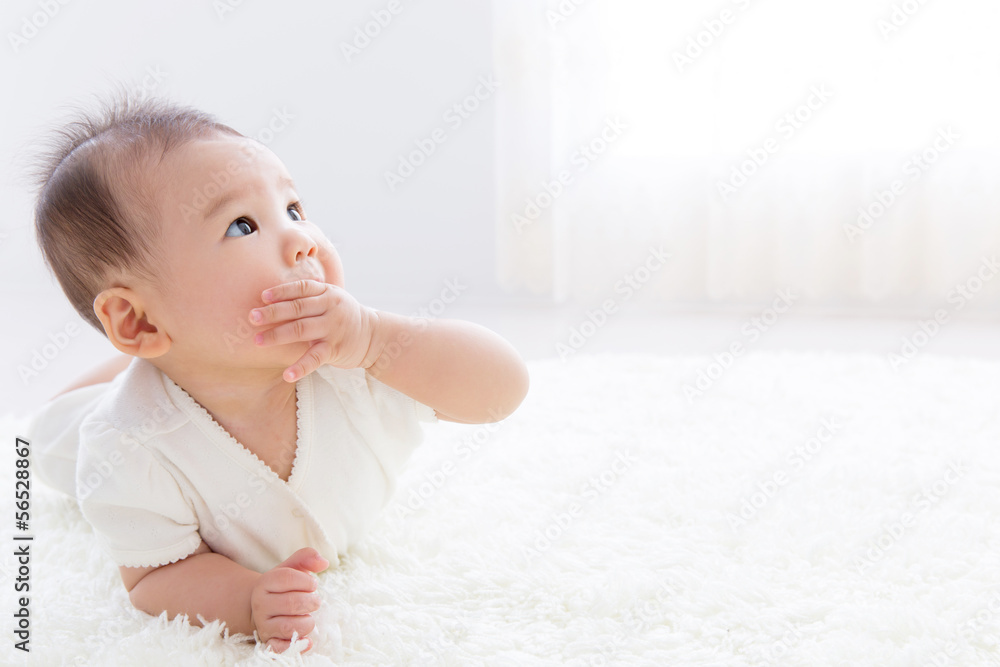 asian baby relaxing on the carpet