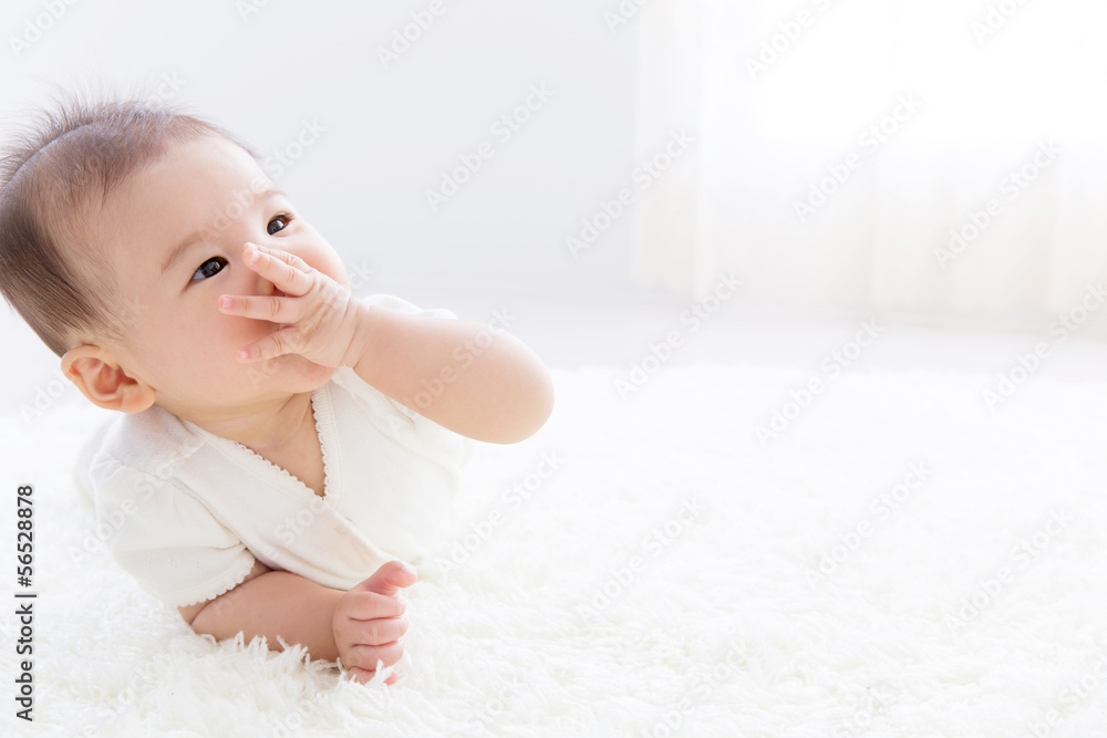 asian baby relaxing on the carpet