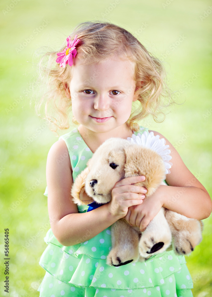 little girl with teddy bear outdoors