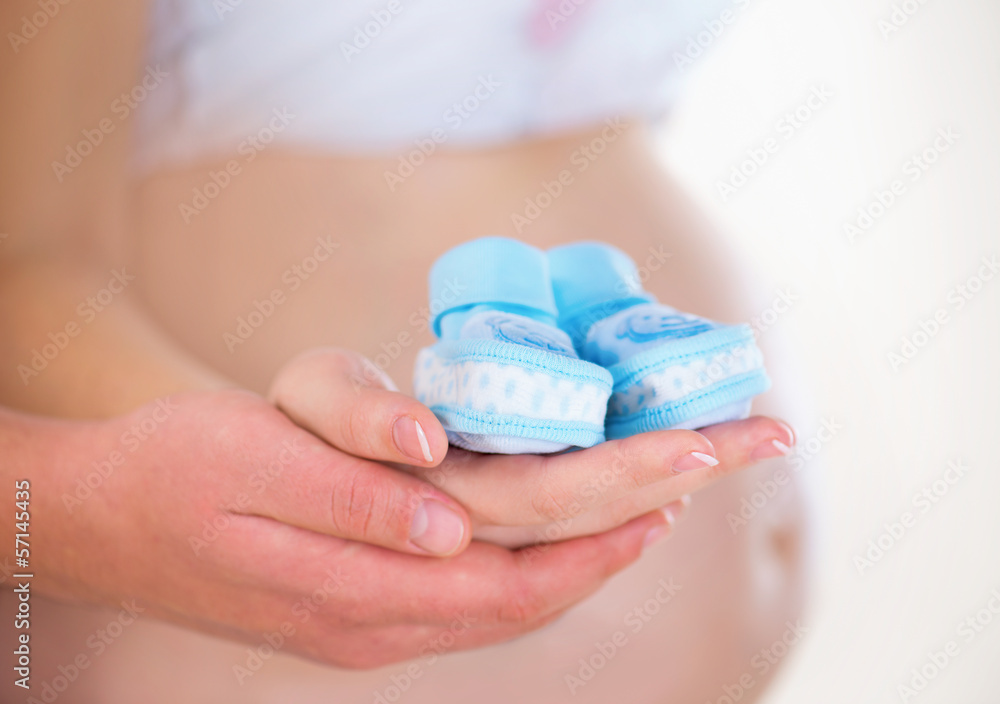 Pregnant Woman and her Husband holding Baby Shoes