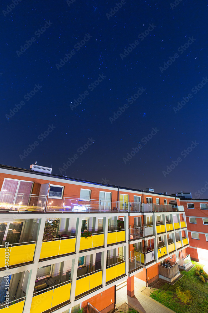 Blue sky with shiny stars over apartment building in Poland