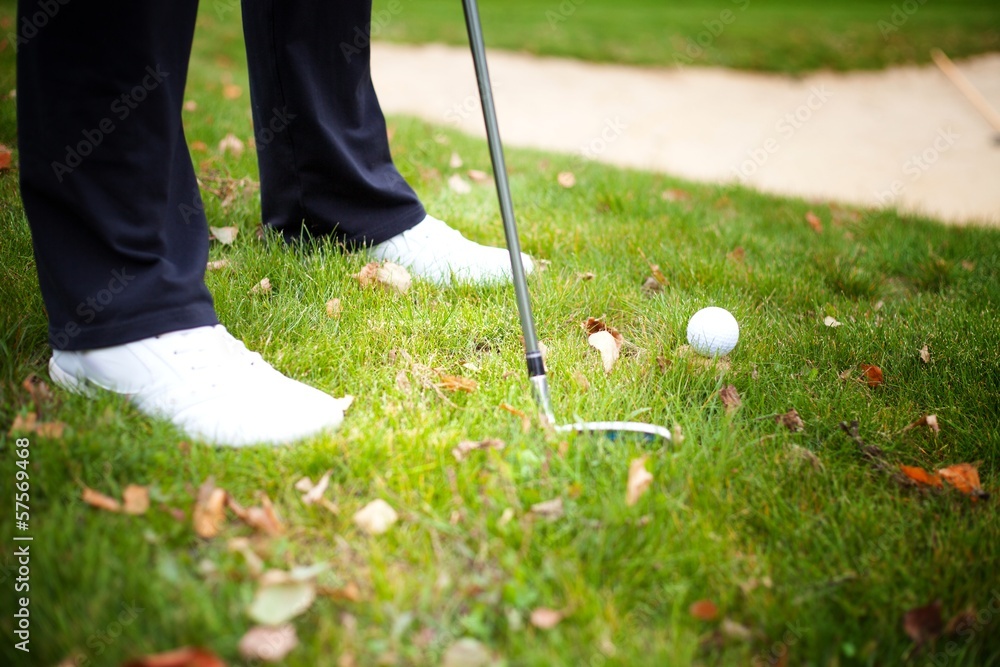 Playing golf with club and ball, preparing shot