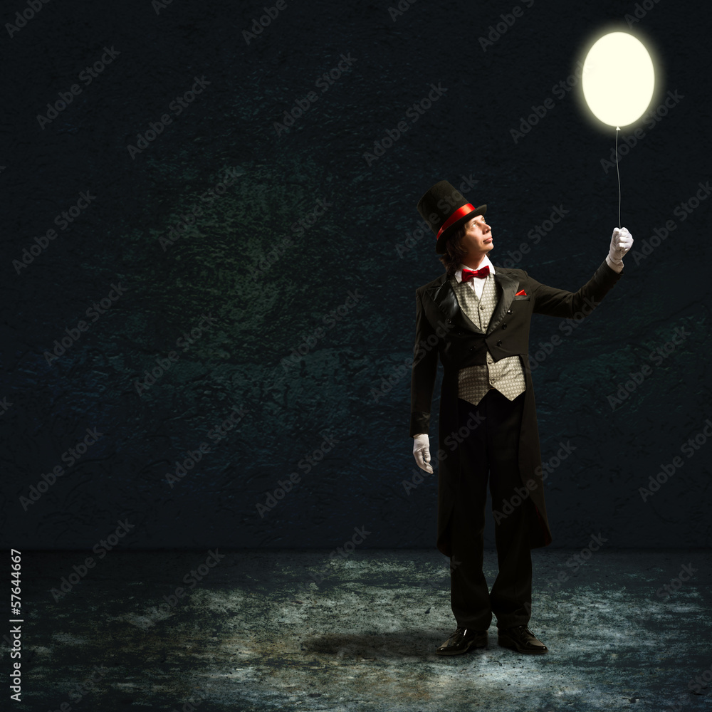 magician holding a glowing balloon