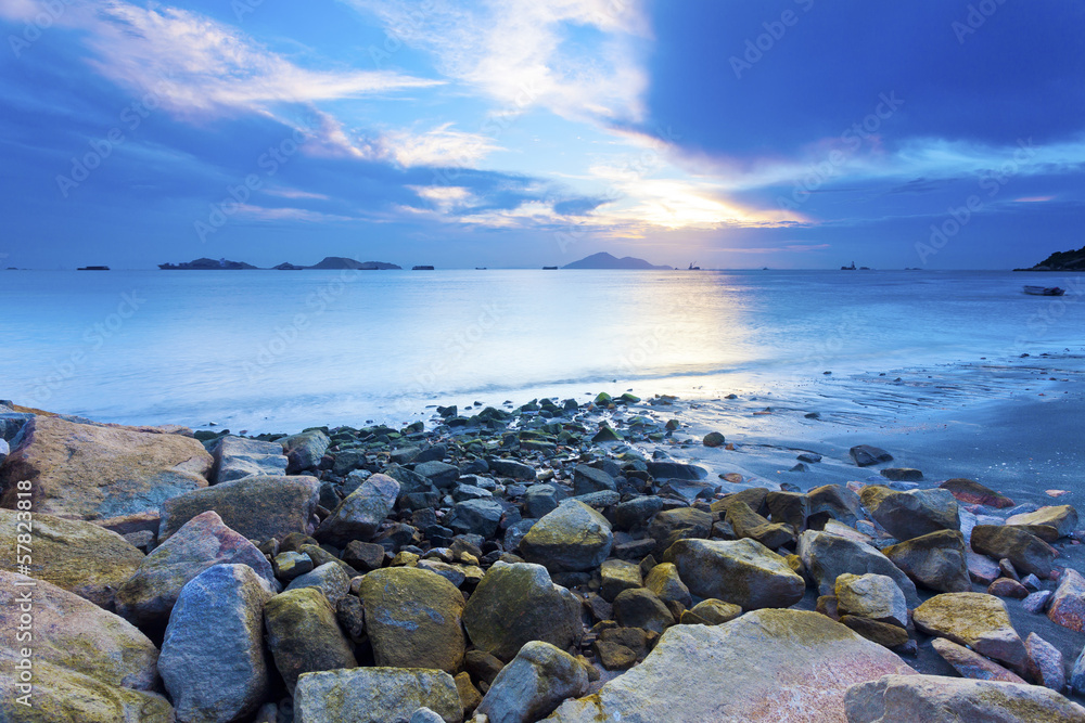 日落海岸，海石背景