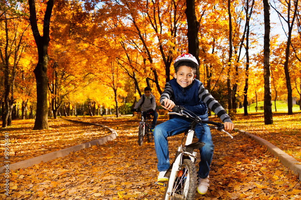 Happy black brothers ride in park