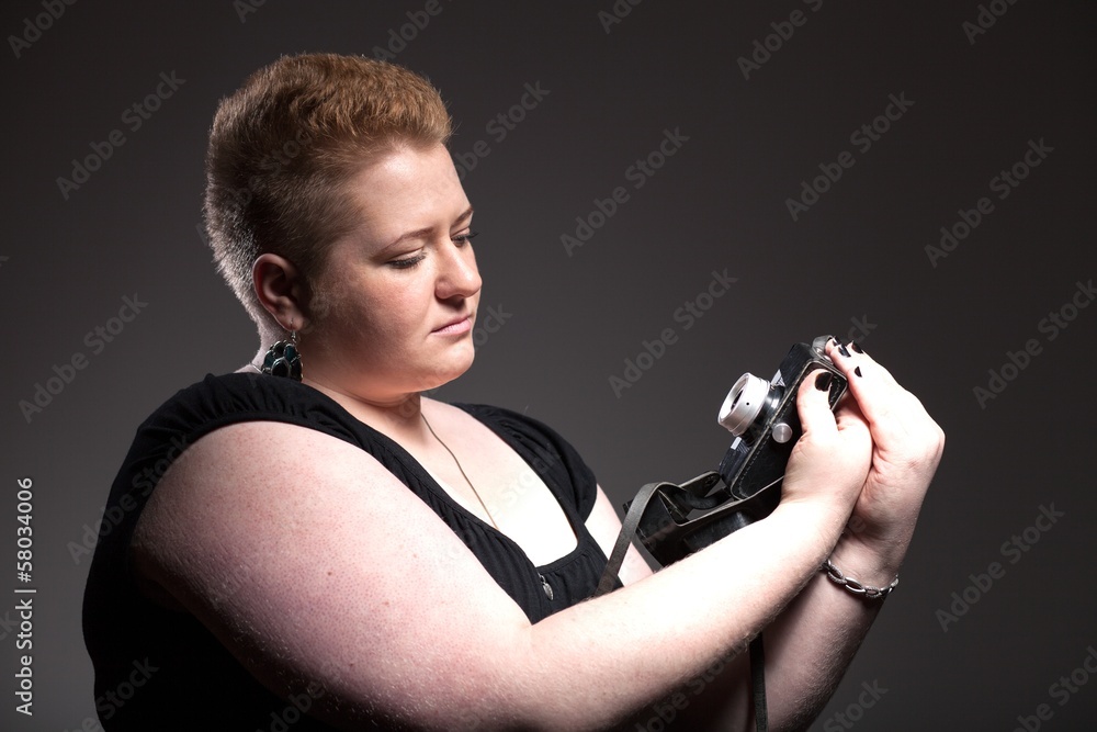 Chubby woman taking pictures of old camera