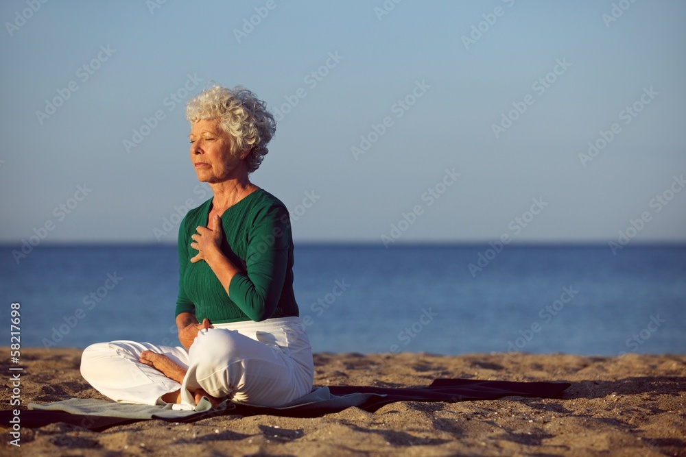 海边冥想的资深女性