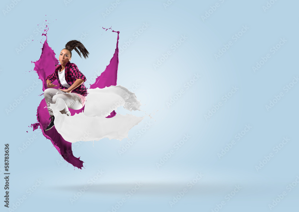 young female dancer jumping with splash of paint